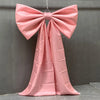 A pink satin bow with long tulle drape used for event decor.
