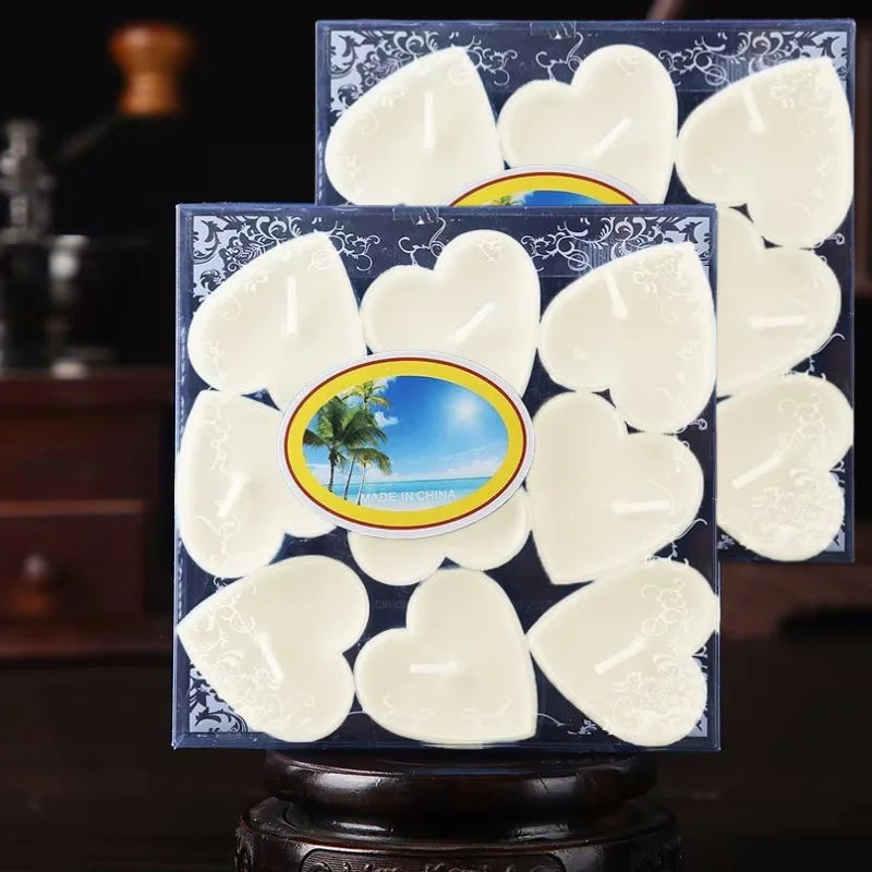 Un ensemble de bougies parfumées en forme de cœur blanches présentées dans une boîte bleu foncé.