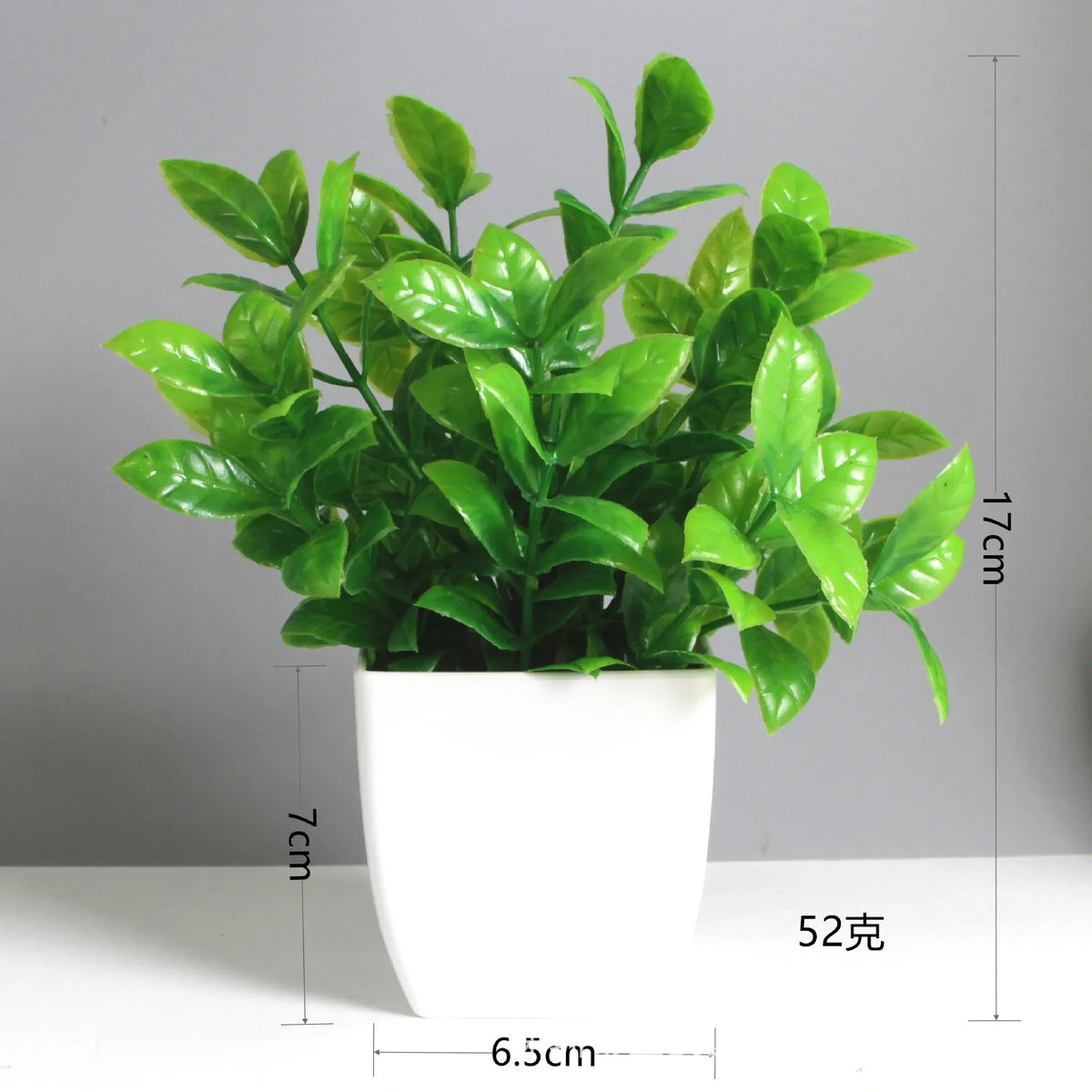 A vibrant green artificial bonsai plant with eucalyptus leaves in a white pot.