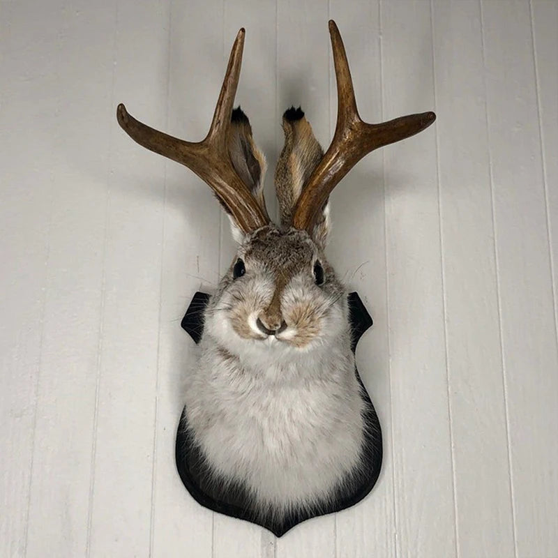 A decorative bunny head with antlers mounted on a wall.