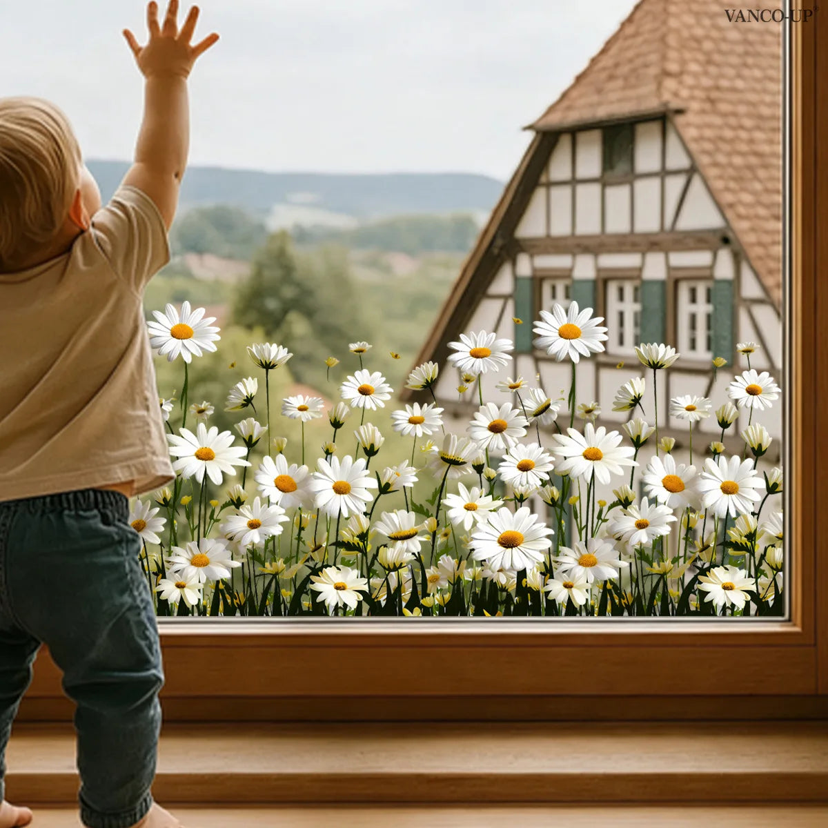 A child stands in front of a window decorated with white and yellow daisy flowers.