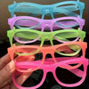 A stack of five glow in the dark party glasses in various colors, held by a hand.