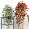 A display of silk morning glory vine hanging flowers in white and red on a wooden stand.