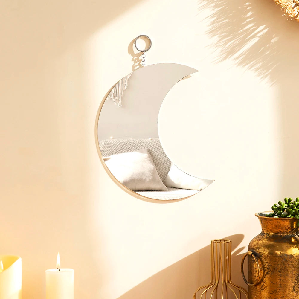 Gold moon acrylic wall mirror with fringe hanging on a beige wall
