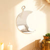 Gold moon acrylic wall mirror with fringe hanging on a beige wall