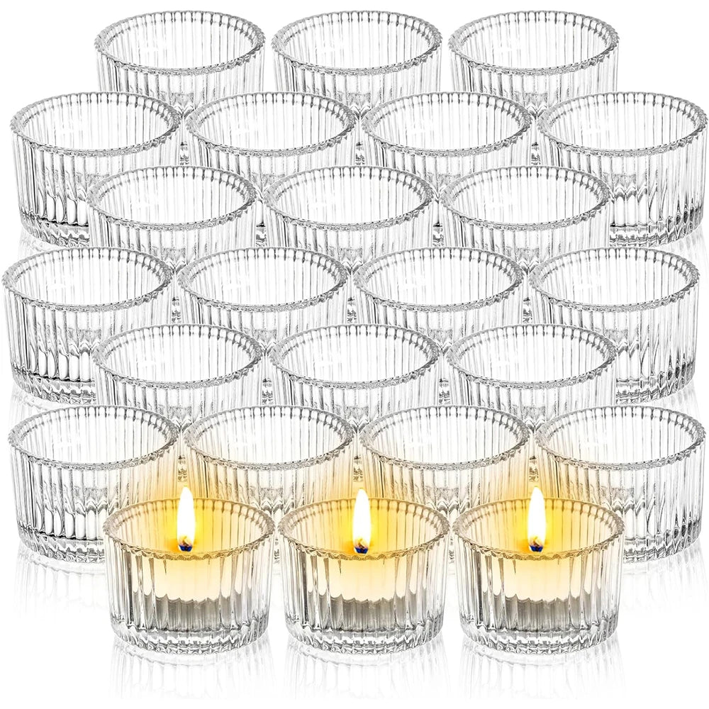 A collection of clear glass tealight candle holders and votives arranged in various sizes.