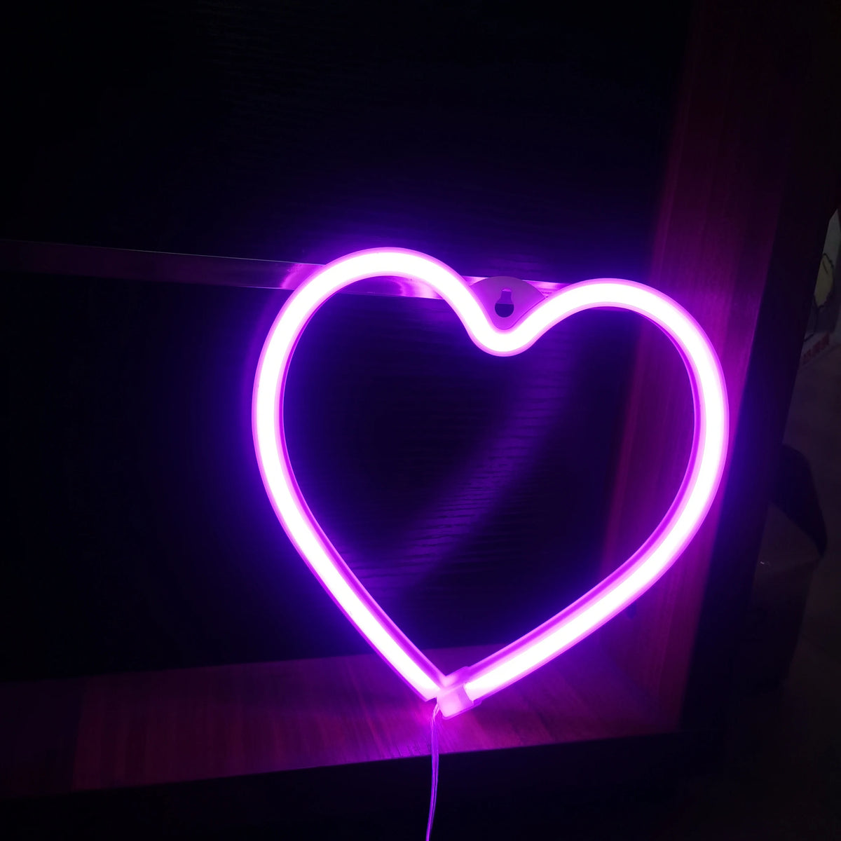 A glowing neon heart sign shaped like a butterfly for decoration or gifting.