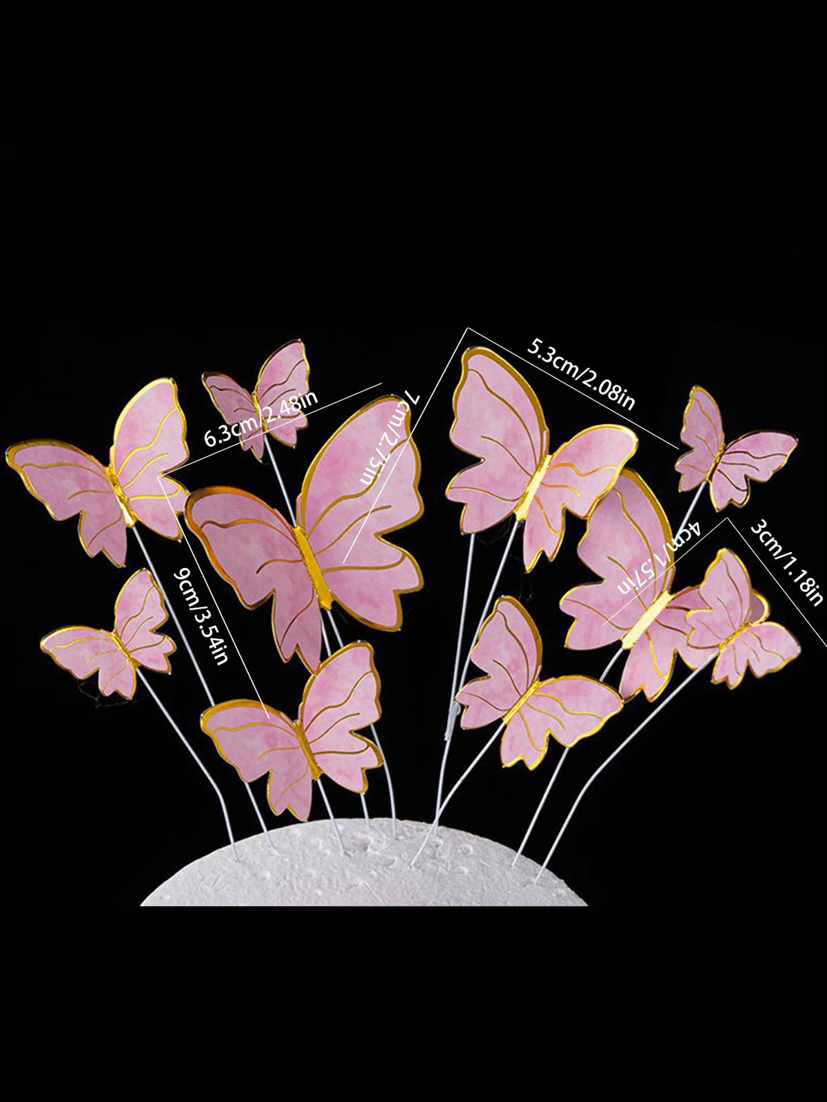 A set of five pink butterfly cake toppers with various sizes and gold accents displayed on a white surface.