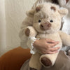 Une personne tient un jouet en peluche Kawaii de Highland Calf beige clair.