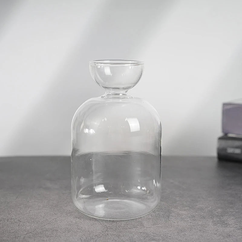 Klares Glas-Hydroponik-Pflanzer mit breiter Basis und abgerundetem oberen Teil auf dunkler Oberfläche.