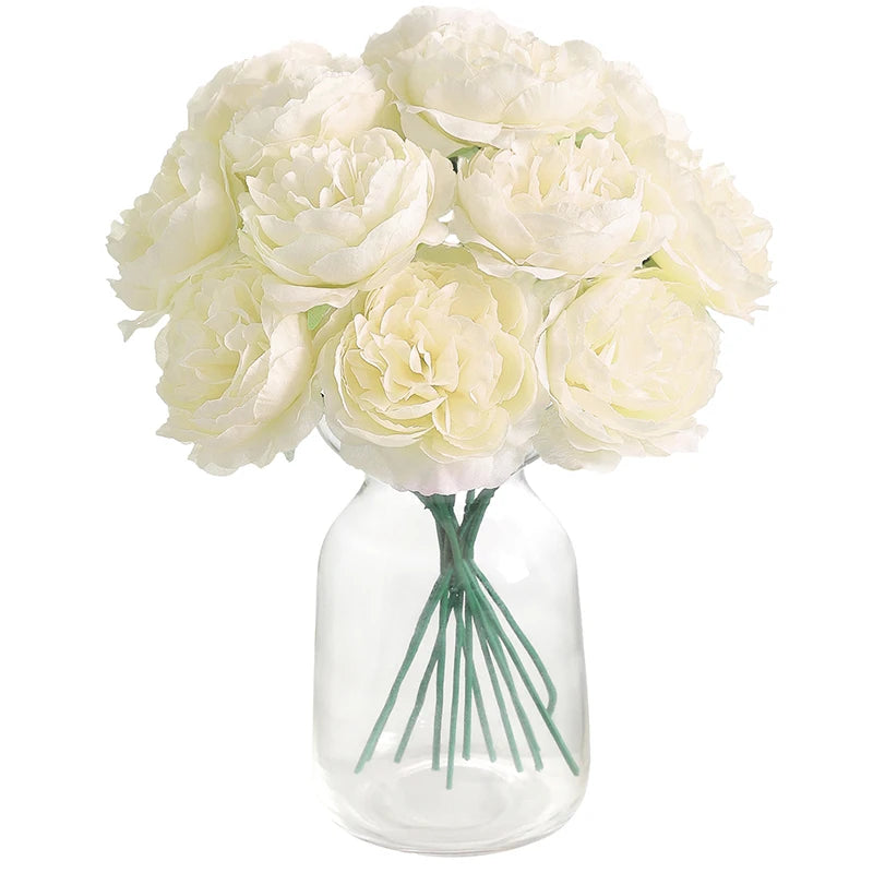 A bouquet of six creamy white artificial peony flowers arranged in a clear glass vase.
