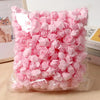 A clear plastic bag filled with pink PE foam artificial rose flowers for DIY decor.