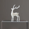 A white resin ornament of an elk deer with antlers standing on a clear glass base.