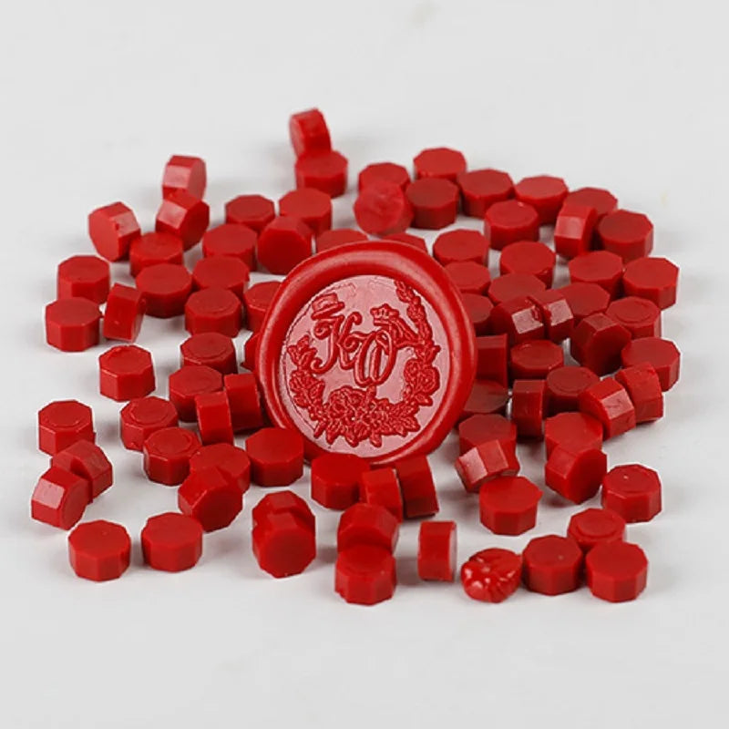 A pile of small, round, red wax sealing beads for custom stamps.