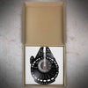 A vinyl record wall clock featuring a black face and a red and white second hand, displayed in its cardboard packaging.