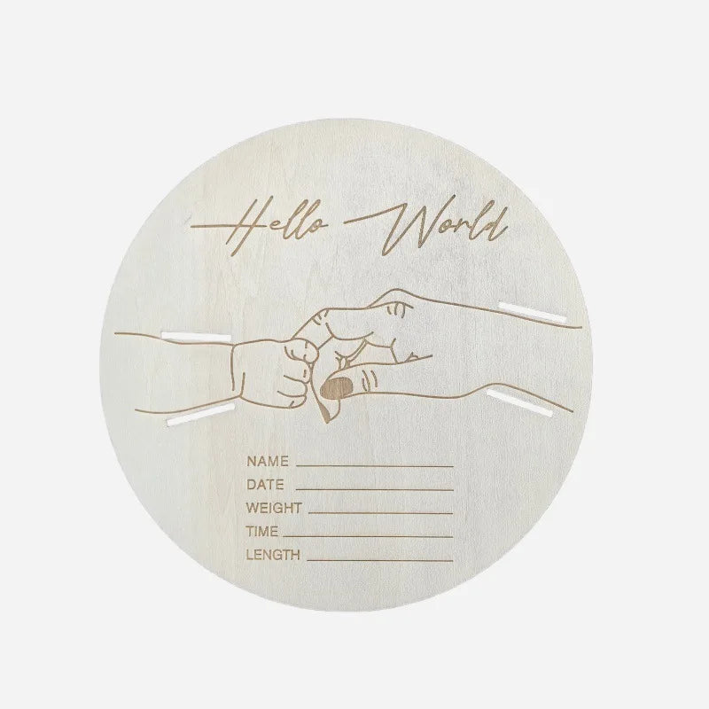A light wood sign with handprints and the text Hello World, featuring lines for name, date, weight, time, and length.