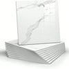 A square white marble peel-and-stick wall panel displayed on a stack of white panels.