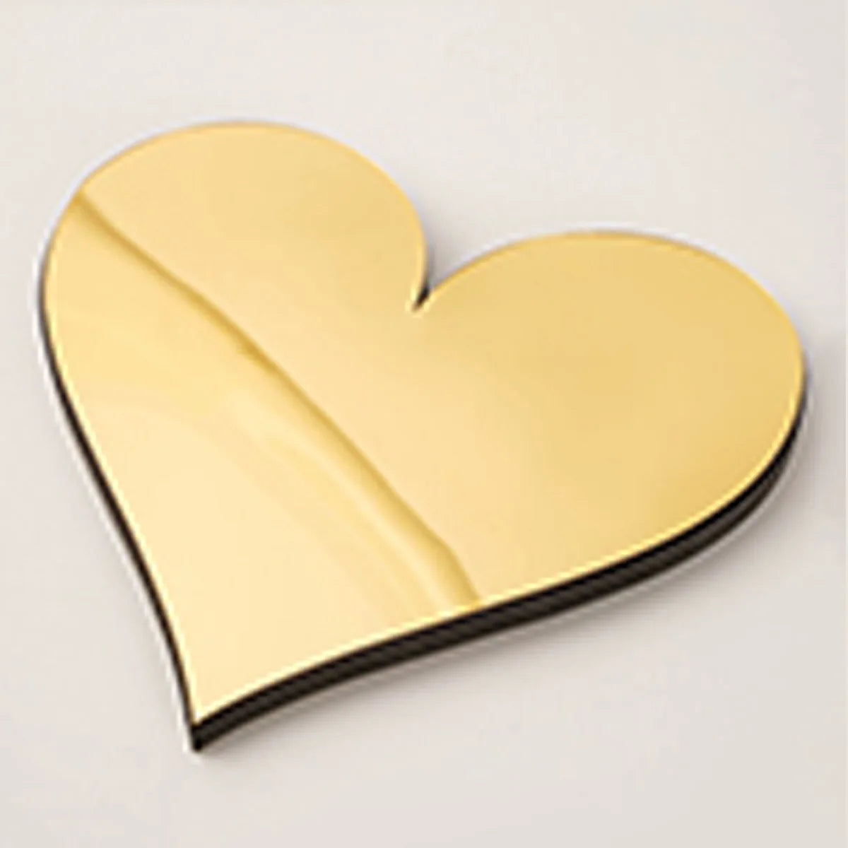 A gold acrylic mirror heart shape wall sticker for decorative purposes.