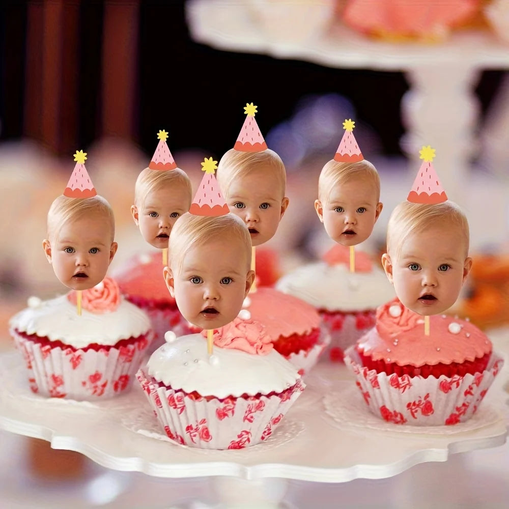 A display of pink and white cupcakes decorated with colorful toppers for a baby's first birthday party.