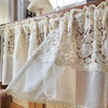 Beige sheer curtain featuring delicate floral embroidery and lace trim.