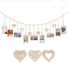 A delicate gold photo display garland featuring heart-shaped photo frames hanging in a line.