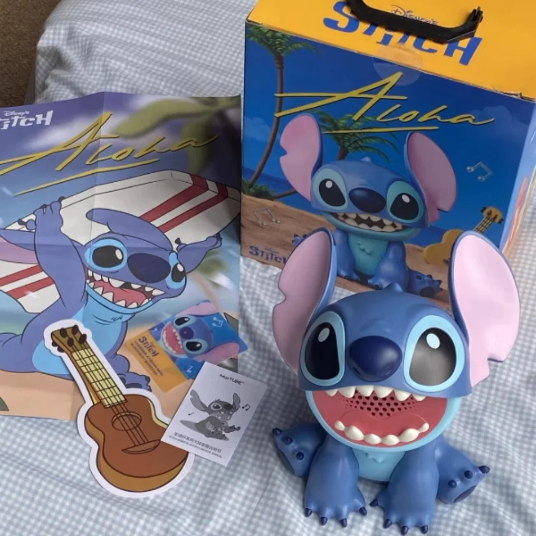 Stitch plush toy in blue and pink ears sitting next to its packaging box.