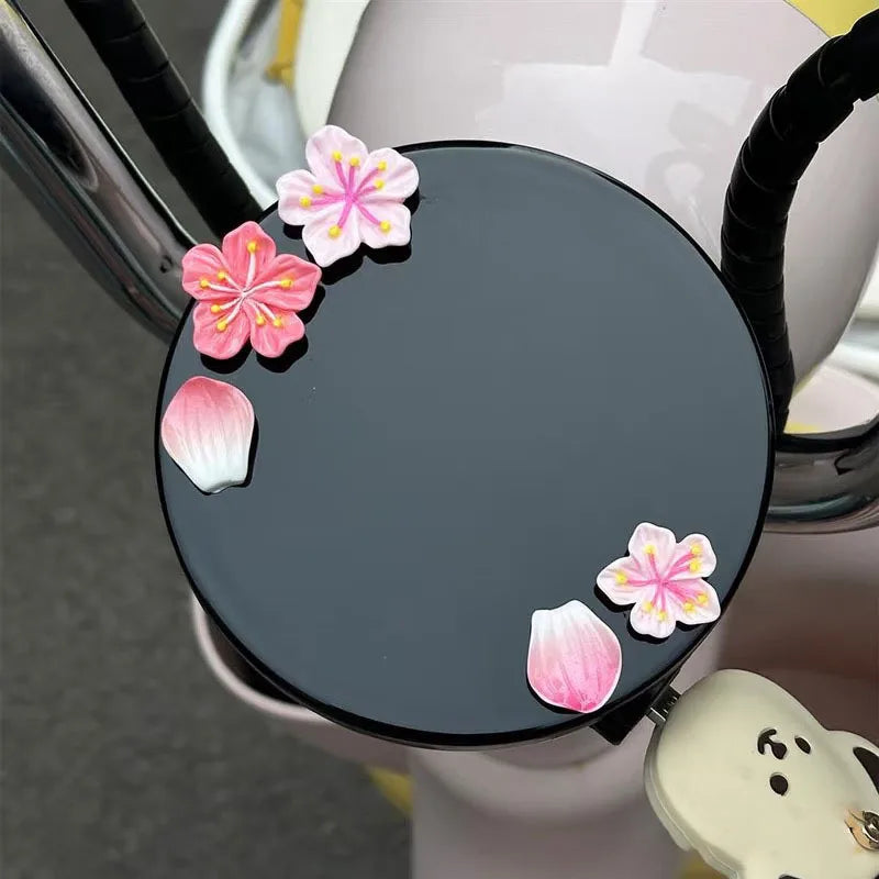 A black dashboard ornament featuring pink and white 3D peach blossom flowers.