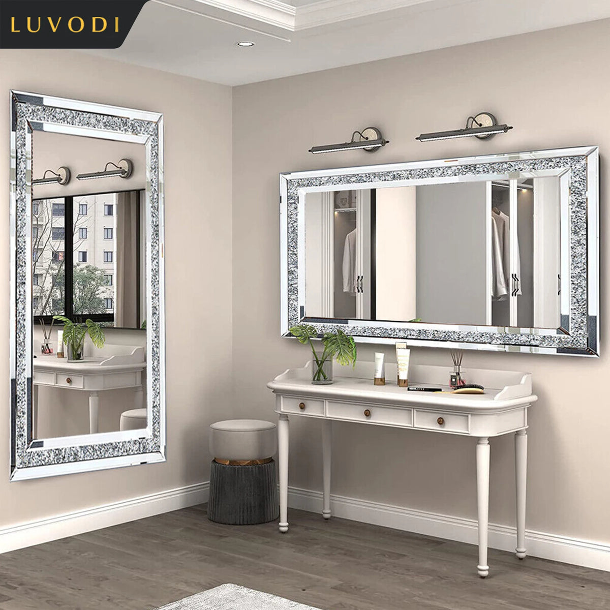 A white vanity table with a large silver crystal rhinestone mirror mounted on a beige wall.