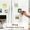 A hand places a Christmas-themed acrylic fridge magnet onto a white refrigerator door decorated with various holiday magnets.