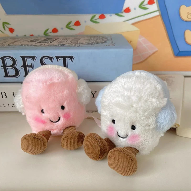 A set of two fluffy marshmallow plush toys, one pink and one white, with brown feet, displayed next to a box.