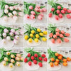 A collection of realistic artificial tulips in various shades of pink, white, and yellow arranged for home or wedding decor.