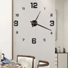 A large, modern wall clock with a white background and black numbers and hands is displayed in an indoor setting.
