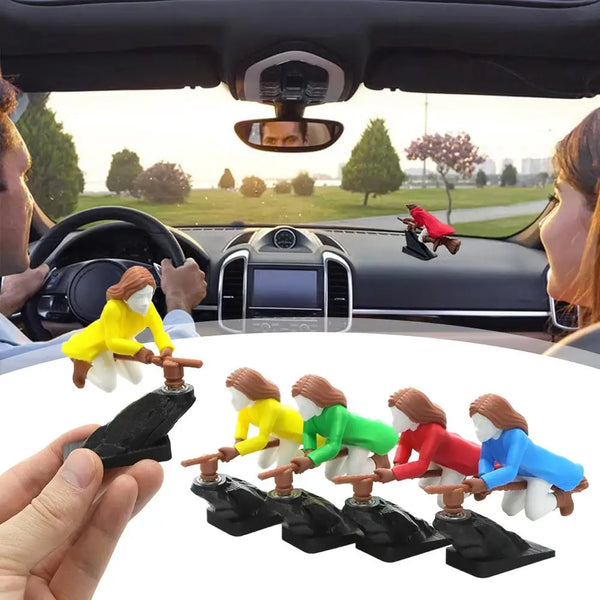 A set of witch and wizard flying carriage dashboard decor figures in various colors are shown being held by a hand.