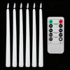 A set of six white taper candles and a remote control with on/off switches and dim controls.