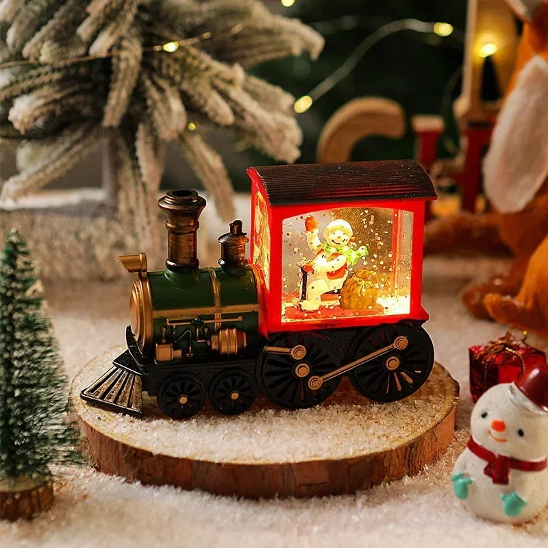 A miniature Christmas train with LED lights and a water-filled crystal ball displayed on a wooden surface.