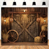 A rustic wooden backdrop featuring a large barn door, wooden wagon wheels, and hay decorations.