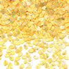 A pile of gold sea shell PVC sequins used for nail art and craft decoration.