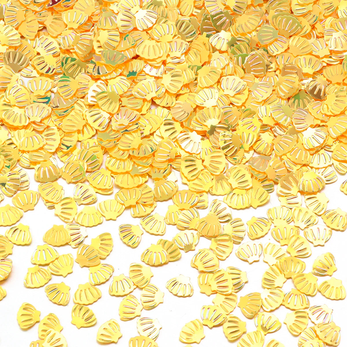 A pile of gold sea shell PVC sequins used for nail art and craft decoration.