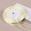 A roll of pale yellow satin ribbon is shown on a white box, ready for gift wrapping or crafts.