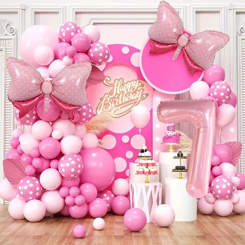 A pink and white balloon garland arch kit featuring numerous balloons in various shades of pink and white, including a large 