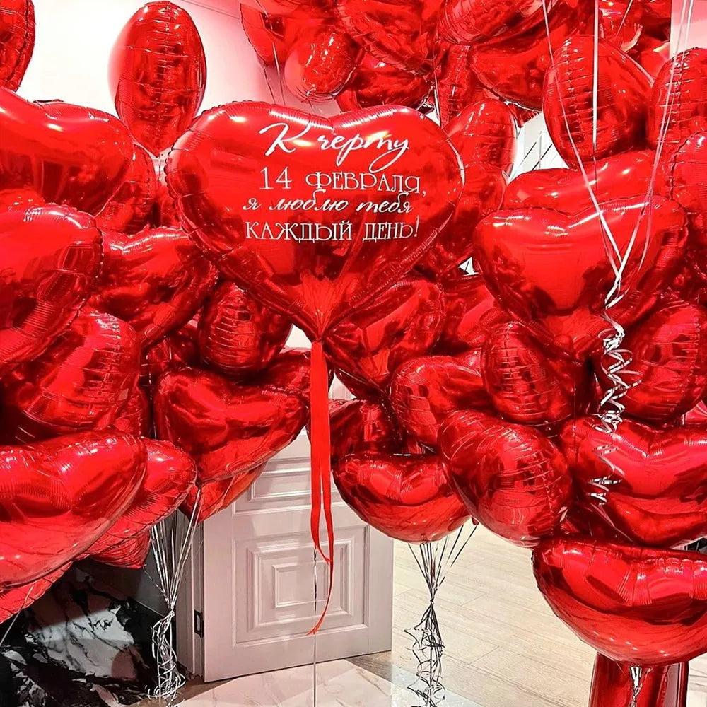 A dense arrangement of red heart-shaped foil balloons tied together with ribbons.