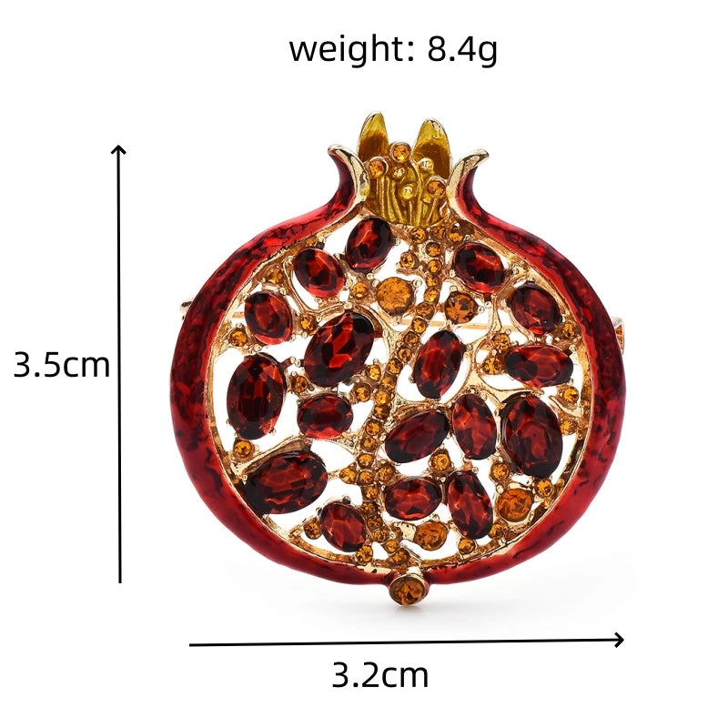 A red crystal pomegranate brooch pin featuring gold accents and ruby-colored stones.
