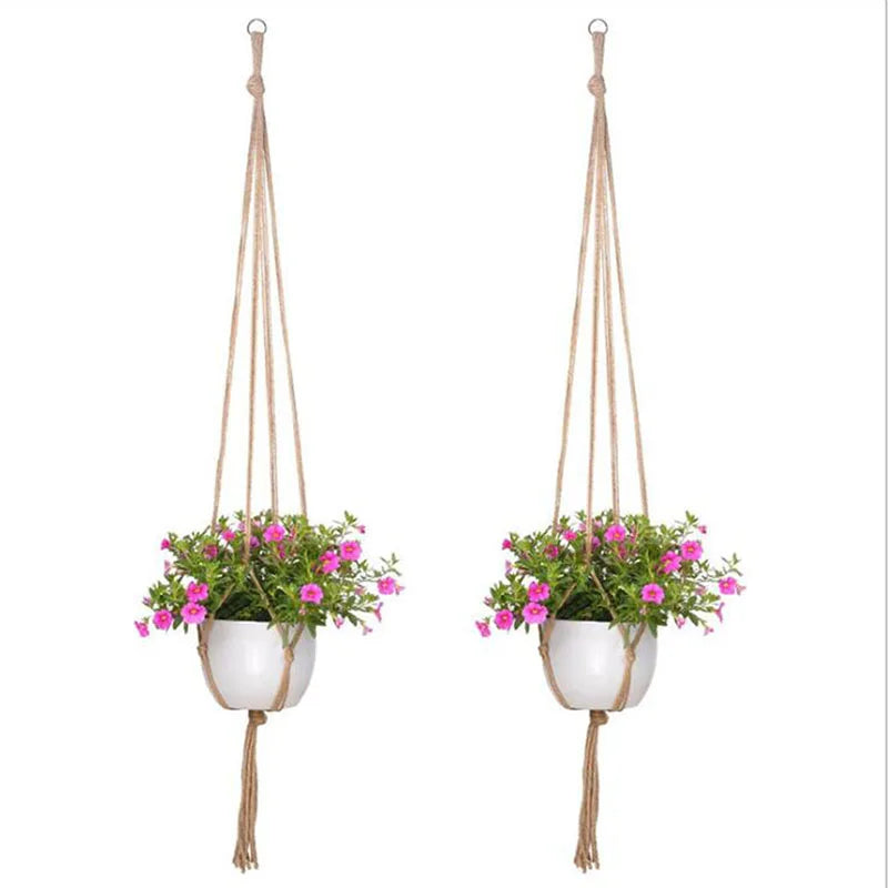 Handmade macrame plant hanger with a woven rope and a small potted pink flower basket hanging from a macrame cord.