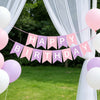 A decorative banner with pink and purple pennants spelling out Happy Birthday strung across a white fabric archway.