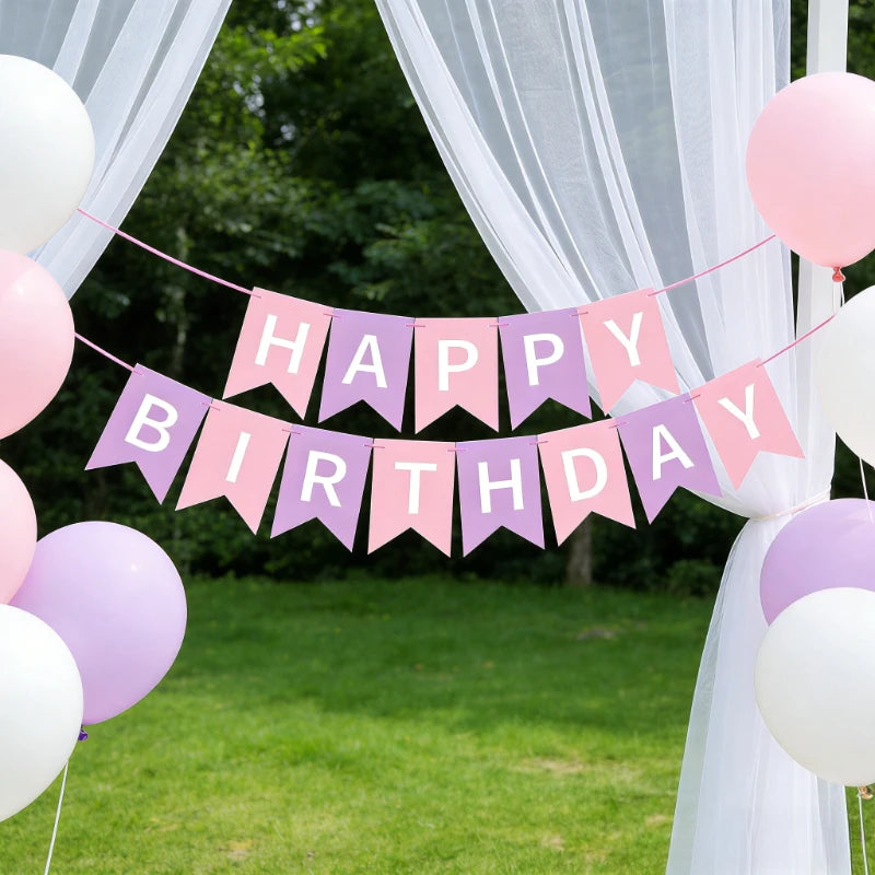 A decorative banner with pink and purple pennants spelling out Happy Birthday strung across a white fabric archway.