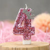 Pink sequin birthday number candle shaped like the number four with a silver crown topper