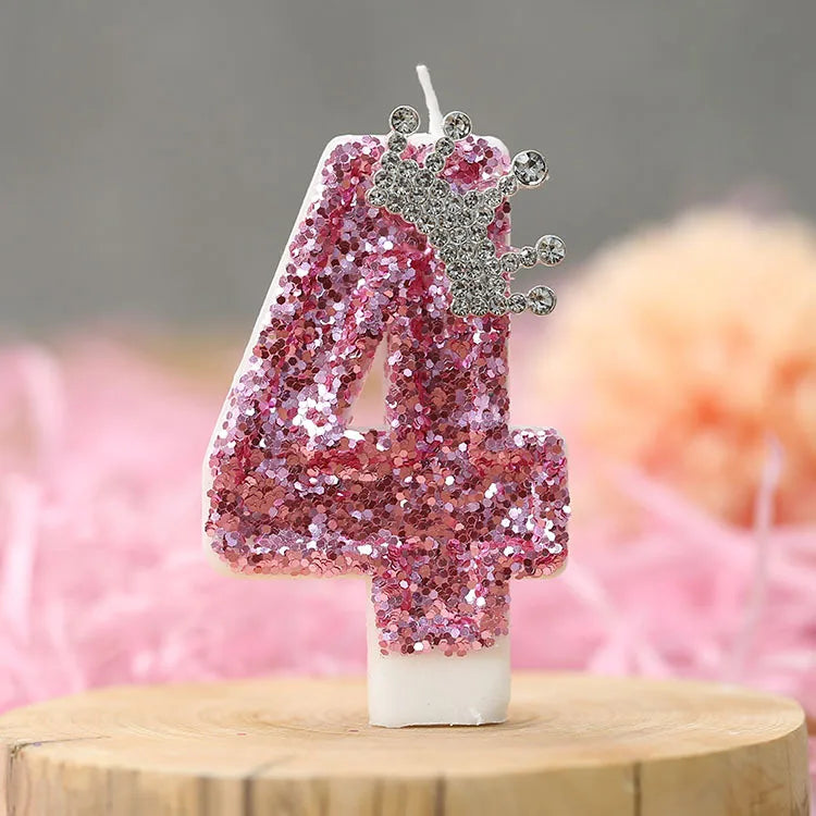 Pink sequin birthday number candle shaped like the number four with a silver crown topper