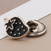 A black fruit-shaped brooch button with a silver finding, featuring a star design and small rhinestones.