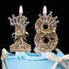Gold glitter number cake topper candles with rhinestone bow on a light blue cake.