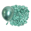 A glossy mint green latex balloon next to a pile of crumpled metallic teal foil balloons.